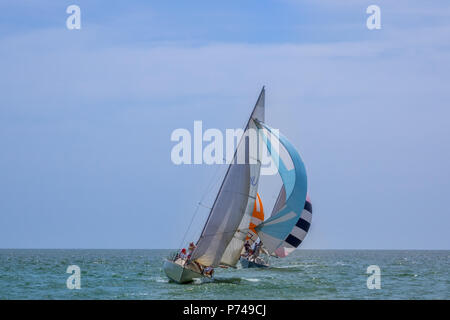 Sonniges Wetter auf dem offenen Meer. Drei Segelyachten mit Spinnakers geht mit einer deutlichen Neigung Stockfoto