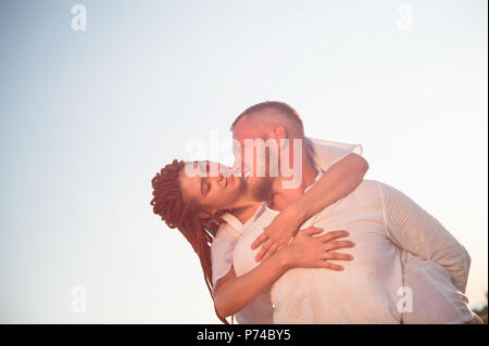 Glücklich lächelnde Junge kaukasier Paar Mann und Frau im Sommer warmen Sonnenuntergang einander lieben Stockfoto