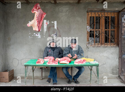 Khidistavi, Georgien - Dezember 1, 2016: Zwei Männer, die den Verkauf von frisch geschlachteten Schwein Fleisch durch die Straße Stockfoto