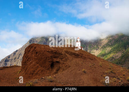 Die Gemeinde La Candelaria auf einem roten Hügel mit grünen Berg, Frontera, El Golfo, El Hierro, Kanarische Inseln, Spanien Stockfoto