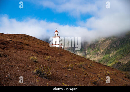 Die Gemeinde La Candelaria auf einem slooped Red Hill mit grünen Berg, Frontera, El Golfo, El Hierro, Kanarische Inseln, Spanien Stockfoto