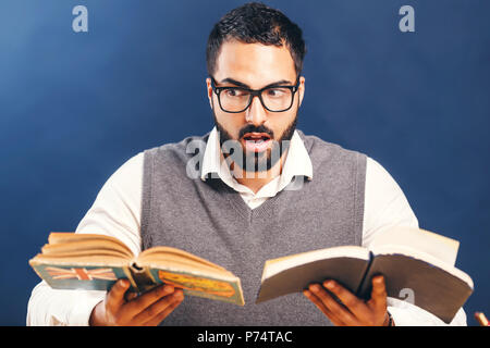Portrait der Östlichen arabischen bärtiger Mann Buch vor blauem Hintergrund Stockfoto