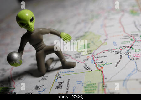 Ein Miniatur extraterrestrische dargestellt mit einer Karte von der Nellis Air Force Base in Nevada. Stockfoto