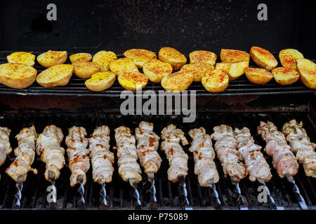 Spieße aus Kartoffeln und Fleisch sowie Spieße auf dem Grill im Freien Stockfoto