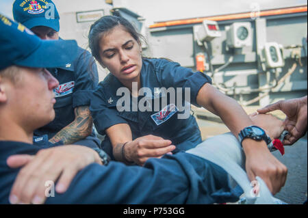 SOUTH CHINA SEA (13. April 2015) Quartermaster 3. Klasse Christina Casillas (rechts), aus San Antonio, gilt eine Schiene zu einem simulierten gebrochenen Arm während einer medial Bohren an Bord der Arleigh-Burke-Klasse geführte Anti-raketen-Zerstörer USS Fitzgerald (DDG62). Fitzgerald ist auf Patrouille in den USA 7 Flotte der Verantwortung für Sicherheit und Stabilität in der Indo-Asia-Pazifik-Region. Stockfoto