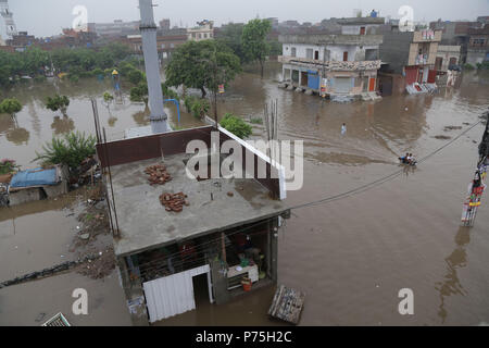 Pakistanische Einwohner von China Regelung durch Überflutete Straße nach dem heftigen Monsunregen in Lahore. Die laufenden vormonsun Regen spell hat wieder einmal schlagen die Stadt. Mindestens 6 Menschen wurden getötet, viele im Regen - Vorfälle verletzt. Gnadenlos als 238 mm Regen weitere drei Stunden den größten Teil der Stadt, die sich in den schlimmsten Staus sowie ernsthafte Unannehmlichkeiten für die Bürger überschwemmt. Das Met Office hat gesagt, dass aufgrund der hohen Druck Monsun Ströme durchdringen im Land, die Punjab Hauptstadt sowie anderen Städten, weiterhin Regen für die nächsten zwei zu erhalten d Stockfoto