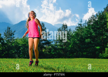 Kleines Mädchen hört Musik mit Player und Kopfhörer. Stockfoto