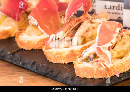 Pintxo von Jabugo-schinken mit karamellisierten Zwiebeln und Sardinen aus dem Kantabrischen Stockfoto