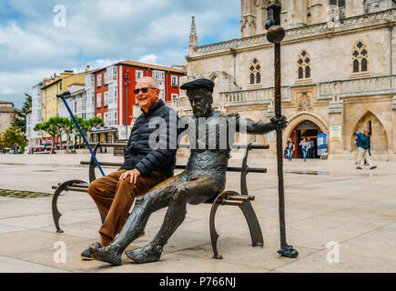 Burgos, Spanien - 13. Juni, 2018: Ältere Menschen stellt neben einem müden Pilger statue am Plaza Rey San Fernando in Burgos, Spanien - Camino de Santiago siehe Stockfoto