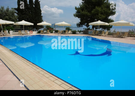 Lefkada, Griechenland - 11. Mai 2013: Blick auf den blauen Pool und weißen Sonnenschirme in modernes Hotel an der Küste des Ionischen Meeres in Griechenland. Stockfoto