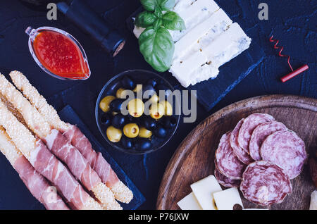 Tabelle mit mediterranen Vorspeisen, Tapas und Antipasti. Verschiedene italienische Küche. Leckerer Snack auf Party oder Picknick. Schneidbrett mit mir Stockfoto