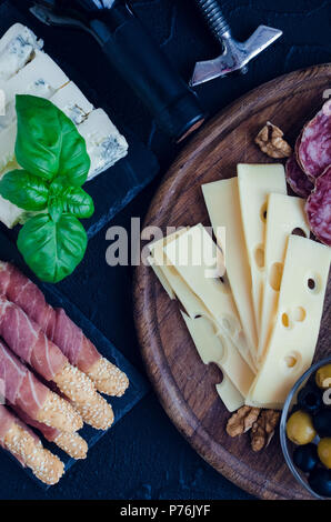 Tabelle mit mediterranen Vorspeisen, Tapas und Antipasti. Verschiedene italienische Küche. Leckerer Snack auf Party oder Picknick. Schneidbrett mit mir Stockfoto