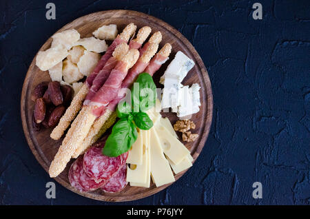 Holzbrett mit mediterranen Vorspeisen, Tapas und Antipasti. Verschiedene Bankett Essen im italienischen Stil eingerichtet. Leckerer Snack auf Party. Schneidebrett w Stockfoto