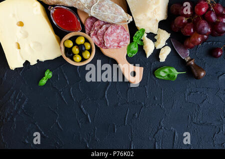 Tabelle mit mediterranen Vorspeisen, Tapas und Antipasti. Verschiedene Bankett Essen im italienischen Stil eingerichtet. Leckerer Snack auf Party. Schneidbrett mit Mea Stockfoto