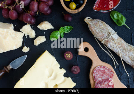 Tabelle mit mediterranen Vorspeisen, Tapas und Antipasti. Verschiedene Bankett Essen im italienischen Stil eingerichtet. Leckerer Snack auf Party. Schneidbrett mit Mea Stockfoto