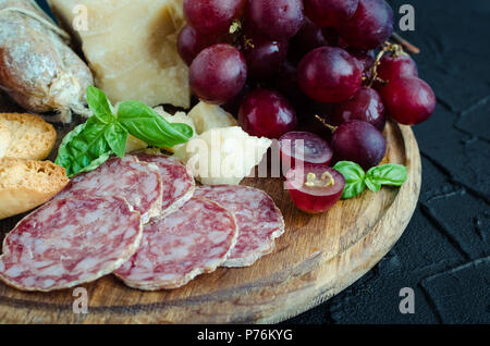 Vorstand mit mediterranen Vorspeisen, Tapas und Antipasti. Verschiedene Bankett Essen im italienischen Stil eingerichtet. Leckerer Snack auf Party. Schneidbrett mit Salami Stockfoto