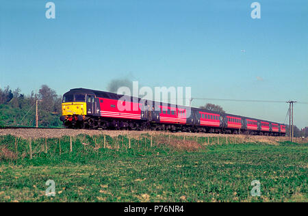 Eine Klasse 47 Diesellok Reihe 47841 arbeiten ein umgeleiteter Jungfrau Bahn Cross Country Service in Shalford Kreuzung am 7. April 2002. Stockfoto