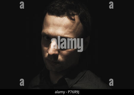 Nahaufnahme Porträt der jungen europäischen Mann über schwarzen Hintergrund, Low Key studio Foto Stockfoto