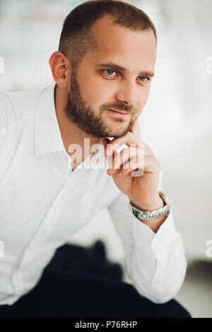 Sicher Mann hält Kinn mit der Hand und die Kamera. Stockfoto