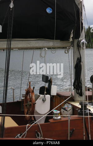 Nahaufnahme der Rad- und Kabine von einem Boot am Ufer vertäut bei Baddeck, Am Ufer des Bras d'Or Lake, Nova Scotia, Kanada Stockfoto