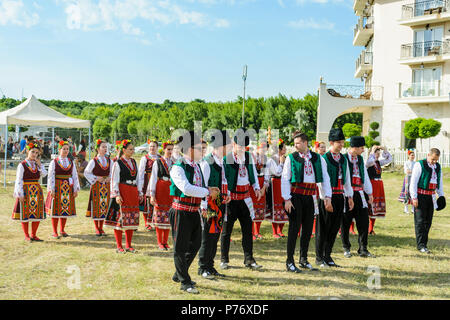 Varna, Bulgarien - 10. Juni 2018: Menschen in authentische Folklore Kostüm in einer Wiese tanzen Bulgarischen traditionellen Tanz namens Horo Stockfoto