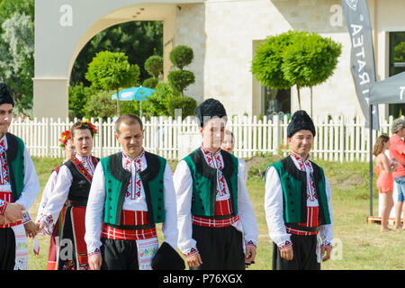 Varna, Bulgarien - 10. Juni 2018: Menschen in authentische Folklore Kostüm in einer Wiese tanzen Bulgarischen traditionellen Tanz namens Horo Stockfoto