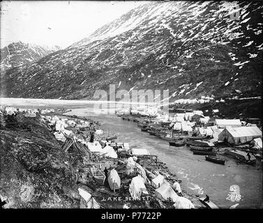 . Englisch: Bennett auf Bennett Lake, British Columbia, Ca. 1898. Englisch: Zeigt eine Meile zwischen Bennett See und Lindeman See, Zeltstadt, scows zum Ufer und Boot Gebäude gebunden. Bildunterschrift auf Bild: "See Benntt 'Original Foto von Eric A. Hegg 73 A; von Larss und Duclos kopiert. Nr. 65 und 2143 erscheint in der unteren rechten Ecke. Klondike Gold Rush. Themen (LCTGM): Flüsse - British Columbia; Seen - British Columbia; Zelte - - British Columbia - Bennett; Scows - - British Columbia - Bennett Themen (LCSH): 1,6 km Fluss (v. Chr.); Bennett, See (ca. 1898 v. Chr.) 1 Bennett auf Bennett Lake, Britisch Stockfoto