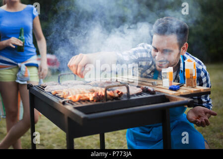 Gerne Studenten mit Grill im Sommer Tag Stockfoto