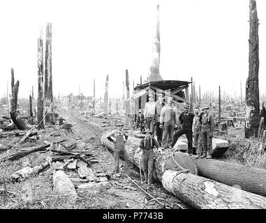 . Englisch: Logging Crew und Esel Motor, Hamilton Logging Company, Ca. 1912. Englisch: Legende auf Bild: 15 PH-Coll 516.1448 Die englische Lumber Company hatte eine Mehrheitsbeteiligung an der Hamilton Logging Company, das Unternehmen unter diesem Namen hat von Ca. 1908 bis 1917, als der Name wurde dem Lyman Timber Company geändert. Hamilton ist eine Gemeinde am Nordufer der Skagit River 10 Meilen östlich von Sedro Woolley in zentralen Skagit County. Es war einst als die Pittsburgh des Westens, weil der Eisen- und Kohlevorkommen in der Nähe dröhnte. Die Stadt wurde für William Hamilton, der homestea benannt Stockfoto