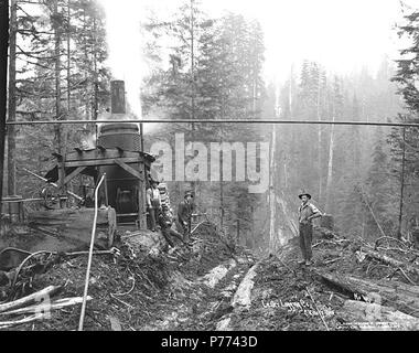 . Englisch: Logging Crew und Esel Motor neben skid Straße, Lester Logging Company, Ca. 1915. Englisch: Legende auf Bild: Lester Logging Co.C. Kinsey Foto. Nr. 4 PH-Coll 516.1721 Die E H Lester Logging Company wurde im Geschäft in der Montesano Bereich von Ca. 1910 bis 1919, als es in den Saginaw Timber Company zusammengeführt. Der E.H. Lester Logging Company hatte zwei - Meile logging Railroad. Montesano, der Sitz der County Grays Harbor County, ist acht Meilen östlich von Aberdeen auf der Chehalis River in der Nähe der Mündung des Wynooche Fluss in Grays Harbor County. In 1862, den Namen Mount Zion war Vorschlagen Stockfoto