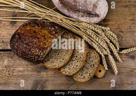 Laibe Brot, Scheiben Brot und Ähren auf Holz Hintergrund. Im rustikalen und ländlichen Konzept. Nahaufnahme Stockfoto