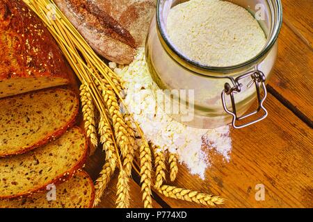 Laibe Brot, Brot, Weizenmehl und Ähren auf Holz Hintergrund. Im rustikalen und ländlichen Konzept. Close Up. Flach Stockfoto