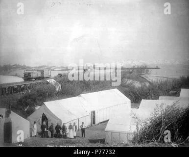 . Englisch: Gruppe von Männern einschließlich Mess Hall Arbeitnehmer posiert vor Zelte mit Eisenbahnschienen, Güterzug mit Bauholz und Brücke im Bau in der Entfernung, Camp 7, möglicherweise an Flagge auf der Copper River, 1908 geladen. Englisch: Konstruktion Fotos der Copper River und Northwestern Railway entlang der Copper River von 1906-1911. Bildunterschrift auf Bild: E.A. Hegg 138. Camp 7. Copper River. PH-Coll 375.70 Themen (LCTGM): Railroad Konstruktion & Wartung - Alaska - Flagge zeigen; Eisenbahnen - Alaska - Flagge zeigen; Workcamps - Alaska - Flagge zeigen; Eisenbahn Bau Arbeiter - Alaska - F Stockfoto