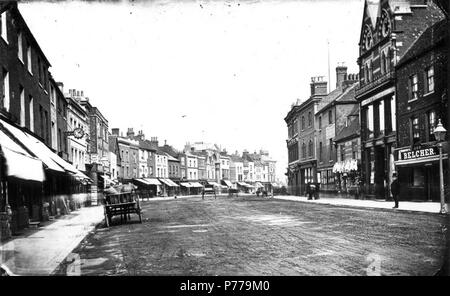 Englisch: Broad Street, Lesen, auf der Suche nach Osten, C. 1870. Nordseite: Nr. 28 (John Player, Uhrmacher, mit einer Uhr an einer Halterung vor dem Geschäft); Nr. 27 (Woolpack Inn); Nr. 26 (E. Fisher, Cookham Shoe Warehouse); Nr. 15 und 16 (Harry Sims, Bettwäsche Draper); Eingang zur Markthalle und Corn Exchange; Nr. 6 (John Stow, Mineralwasser Hersteller und Großhandel Konditor). Südseite: Nr. 113 (James Macaulay, Drucker und Buchhändler); Nr. 112 (Edward Woodman, Schneider und Kammgarn Draper); Nr. 110 und 111 (Heelas, Söhne und Firma, die Draper) und Nr. 109 (John Belcher, Metzger). 1870-1879 Stockfoto