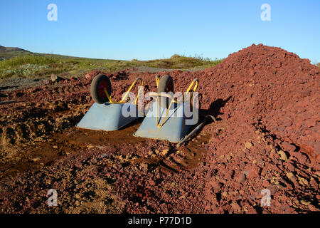 Blau und Gelb Schubkarren in die Rote Erde Stockfoto