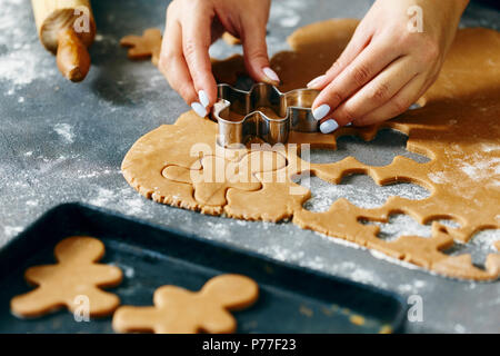 Weihnachten Lebensmittel Konzept. Frau kocht Gingerbread man Cookies in Weihnachten hautnah. Weihnachten Dessert Stockfoto