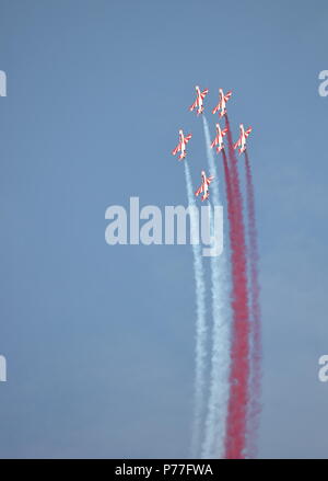 Gruppe von sechs Sport Flugzeuge in der Luft fliegen während der Air Show verlassen weiß-roten Rauch hinter Ihnen, Spektakuläre Akrobatik, Akrobatik Stockfoto