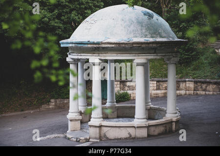 Rotunde durch die grünen Blätter der Bäume Stockfoto