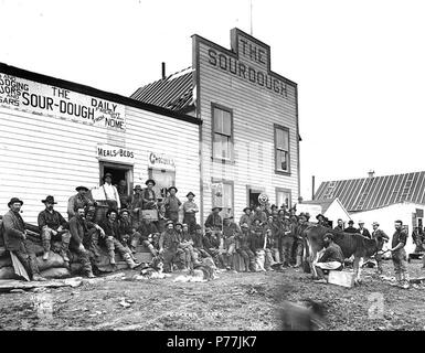 . Englisch: Sauerteig Hotel, Dexter, Alaska, Ca. 1901. Englisch: Zeigt die Gruppe von Männern, die vor einem Haus, schwarzer Mann melken eine Kuh auf der rechten Seite. Bildunterschrift auf Bild: 'Dexter Creek' Bild im Hegg Album 29, Seite 20. Original Foto von Eric A. Hegg 1732; von Webster und Stevens 314. Ein Fächer (LCTGM): Hotels - Alaska - Dexter kopiert; Unterbringung - Häuser - Alaska - Dexter Themen (LCSH): Sauerteig Hotel. ca. 1901 12 Sauerteig Hotel, Dexter, Alaska, ca 1901 (HEGG 284) Stockfoto