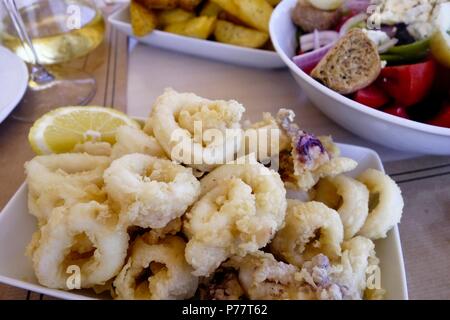 Griechische Küche. Kalamari Frittierte Tintenfischringe mit Salat und Pommes Frites Stockfoto