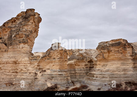 Herrlicher Blick in die Natur des Tales von erodierten Felsformationen unter bewölkten grauen bewölkten Himmel in Castle Rock Badlands, Kansas, USA Umgeben Stockfoto