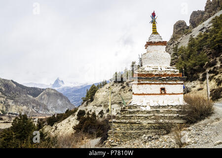 Buddhistische weiße Stupa und schneebedeckten Berggipfel in der Nähe von Braga auf die Annapurna Rundweg, Nepal Stockfoto