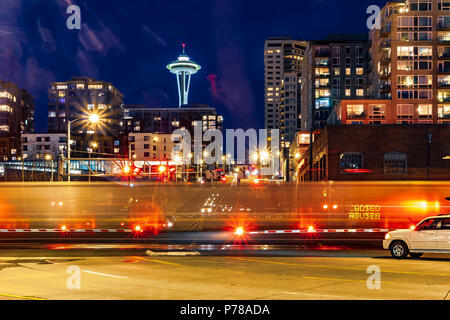 Nachts gibt es leichte Wege auf der Straße mit der Space Needle in der Ferne, Seattle, Washington, USA Stockfoto