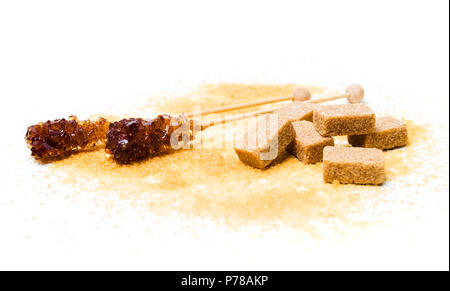 Brauner Zucker Sticks, Kristalle und Würfel auf Weiß Stockfoto