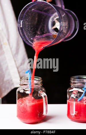 Weibliche gießen Wassermelone Smoothie in einem Glas Stockfoto