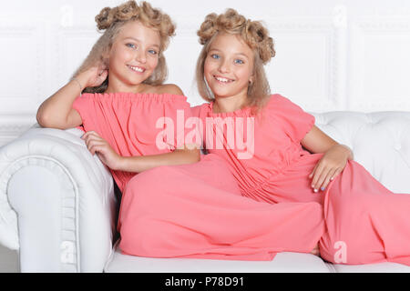 Zwei adorable Zwillingsschwestern im schönen rosa Kleider Stockfoto