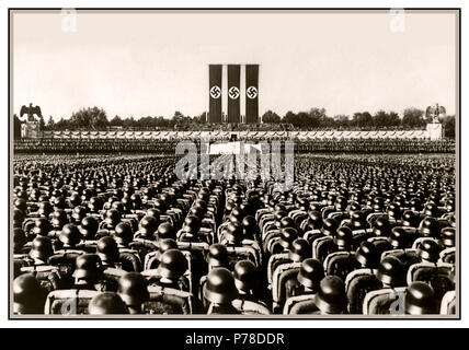 Nürnberg 1930 Waffen-SS-Truppen in polierten Helme in präzise serried Rank an Salute stehen während eines deutschen Nazi Kundgebung vor dem Zweiten Weltkrieg mit großen Hakenkreuzfahnen dominierenden Arena Stockfoto