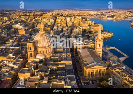 Valletta, Malta - Unsere Liebe Frau vom Berge Karmel Kirche und St. Paul's Cathedral von oben bei Sonnenaufgang mit der antiken Stadt Valletta im Hintergrund Stockfoto