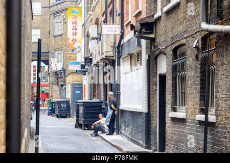 London, Großbritannien, 22. Juni 2018 - die Angestellten im Restaurant eine Pause auf der Rückseite Straße Londons Chinatown Stockfoto