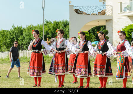 Varna, Bulgarien - 10. Juni 2018: Menschen in authentische Folklore Kostüm in einer Wiese tanzen Bulgarischen traditionellen Tanz namens Horo Stockfoto